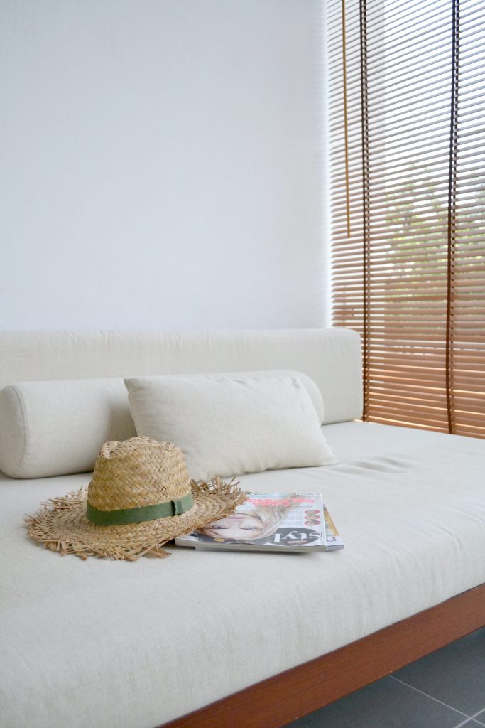 photo of a daybed with a straw hat and some magazines