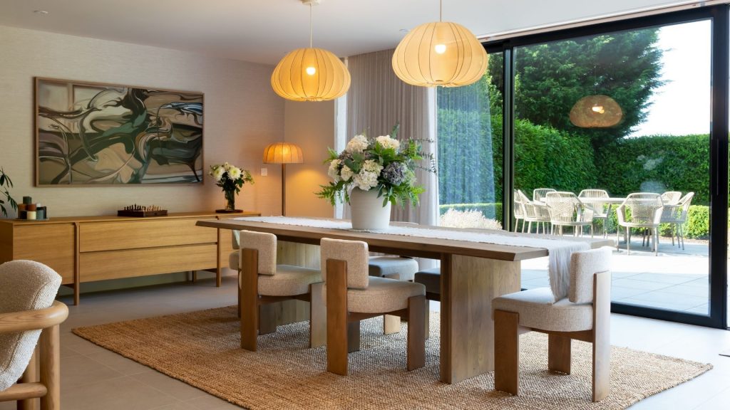 A modern dining space with natural wood furniture, woven textures, and soft lighting. A warm example of minimalist interior design that feels calm and inviting.