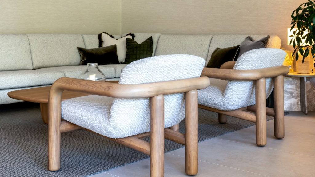 A minimalist living room featuring tactile boucle chairs and a neutral sofa, combining soft textures with clean lines to create warmth and balance.